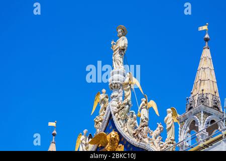 Detail der Markusbasilika aufwendig dekorierter Giebel`s der Darstellung des Schutzpatrons des Heiligen Markus Venedigs mit Engeln`s tiefblauem Himmel,Venedig,Italien Stockfoto